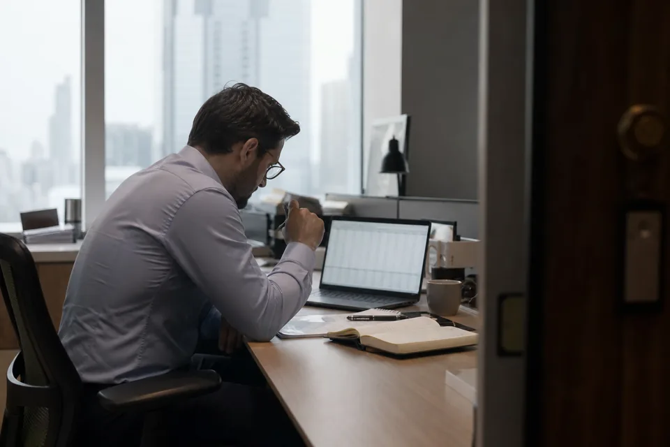Analityk firmy kupującej wierzytelności przegląda oferty na laptopie